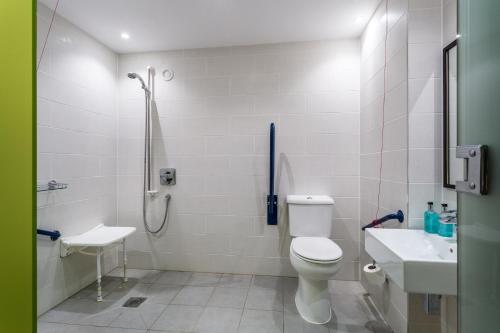 a bathroom with a shower and a toilet and a sink at Holiday Inn Sittingbourne by IHG in Sittingbourne