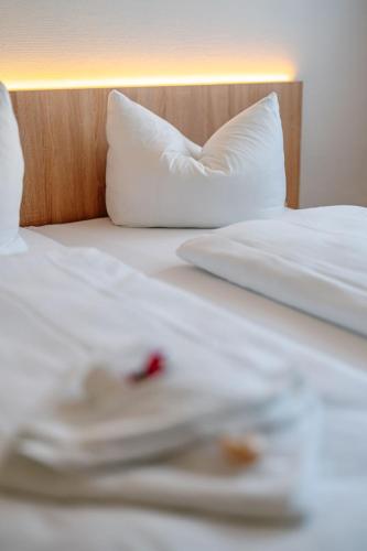 a close up of two beds with white sheets and pillows at Sonnenschein Hotel & Apartments in Heilbad Heiligenstadt