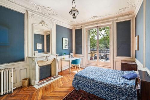 - une chambre avec un lit, un bureau et une cheminée dans l'établissement Appart haussmannien, à Paris