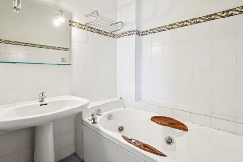 une salle de bain blanche avec un lavabo et une baignoire dans l'établissement Appart haussmannien, à Paris