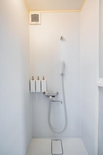 a shower in a white bathroom with a sink at Tamagawa House 2BR in Osaka
