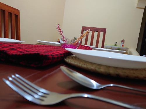 a table with a fork and a bowl on a table at Sero Safaris Hostel in Arusha