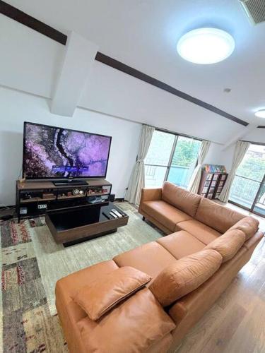 a living room with a couch and a flat screen tv at 池袋駅まで電車で7分 4LDK98m2 in Tokyo