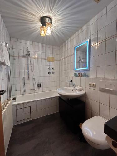a bathroom with a sink and a tub and a toilet at Ferienwohnung Stüberl in Oberammergau