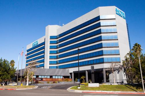a large white building with a lot of windows at Hotel Huntington Beach in Huntington Beach