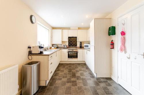 a kitchen with white cabinets and a tile floor at 4 Bedroom Detached, Wi-Fi, Parking, stunning views in Newcastle under Lyme