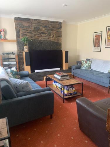 a living room with couches and a flat screen tv at Bodlondeb Holiday Let in Betws-y-coed