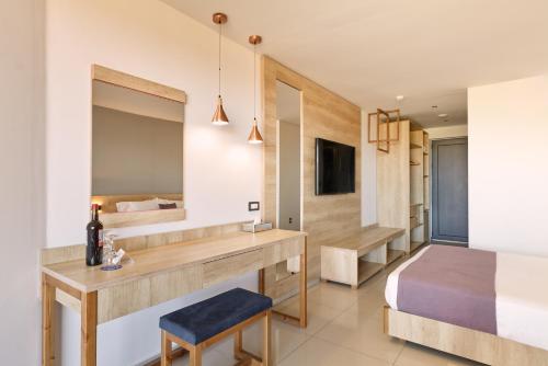 a bedroom with a bed and a desk with a mirror at Galini Palace in Kolymvari