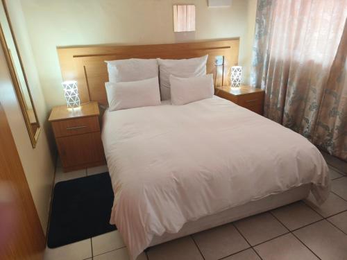 a bedroom with a large bed with white sheets and pillows at Blyde Lodge in Graskop