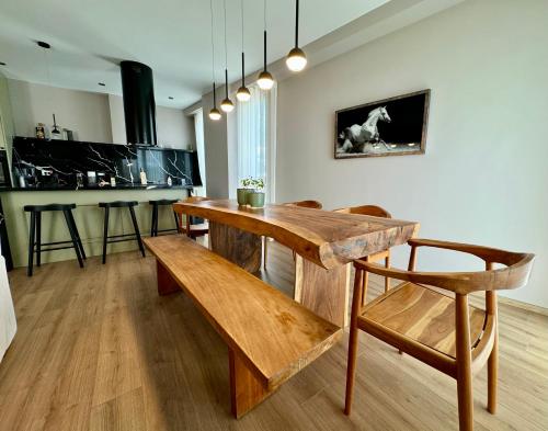 a dining room with a wooden table and a bench at The Boulevard Bliss in Tirana