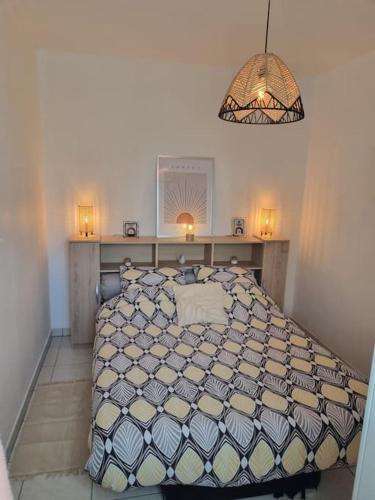 une chambre avec un lit et un lustre dans l'établissement appartement agréable, à Guérande
