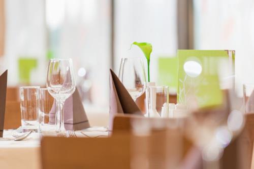 a table with wine glasses on a table at Vulkán Wellness Hotel & Camping in Celldömölk