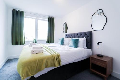 a bedroom with a large bed with green curtains at Spacious and Sunny Flat l River Balcony View ! in London