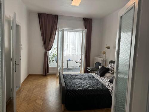 ein Schlafzimmer mit einem Bett, einem Stuhl und einem Fenster in der Unterkunft Airy & Beautiful Downtown Apartment in Bukarest