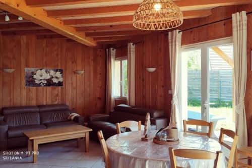 un salon avec une table et un canapé dans l'établissement Gîte les 4 saisons - Intérieur bois - Lac de Chalain, à Marigny