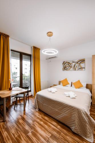 a bedroom with a large bed and a table at Zen Studio 1 with balcony in Bucharest