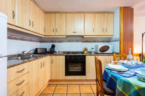 a kitchen with wooden cabinets and a table with a table cloth at Casa Lino in Culla