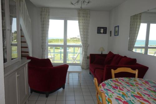 un salon avec un canapé, des chaises et des fenêtres dans l'établissement Nice T3 with terrace and sea view, à Saint-Malo