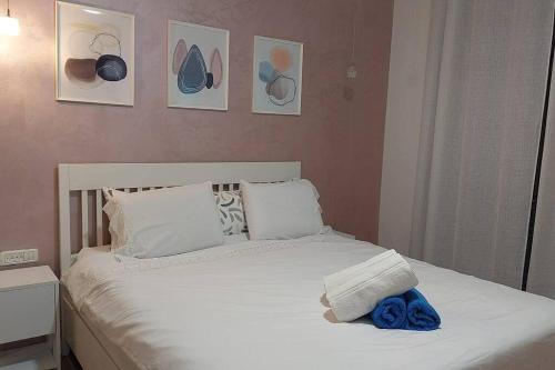 a bed with white sheets and blue towels on it at סוף העולם שמאלה in Idan