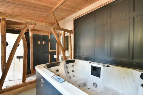 Cette chambre dispose d'une baignoire et d'un plafond en bois. dans l'établissement Jusqu'à 24 pers - Jacuzzi - Terrasses - Barbecue - Réunion de famille ou Séminaire, à Verton