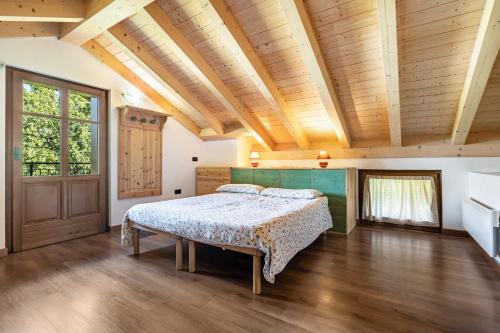 a bedroom with a bed and a wooden ceiling at Agriturismo Malga Riondera in Ala