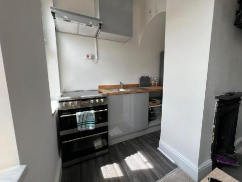 a small kitchen with a stove and a sink at Host & Stay - Regent Street in Kettering