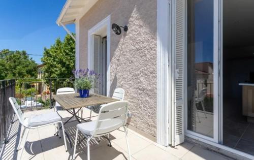 a patio with a table and chairs on a balcony at Remarquable T3 proche plages in Carqueiranne