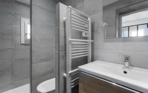 a bathroom with a sink and a toilet and a mirror at Remarquable T3 proche plages in Carqueiranne