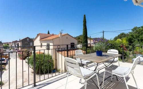 a patio with a table and chairs on a balcony at Remarquable T3 proche plages in Carqueiranne