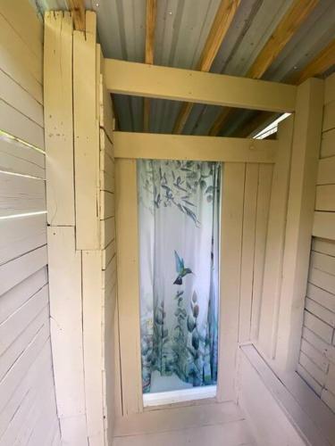 a window in the side of a house with a bird at Pecan Grove Cabin in Huntsville