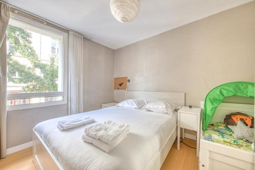 a bedroom with a bed with white sheets and a window at Bel appartement Bordeaux centre in Bordeaux
