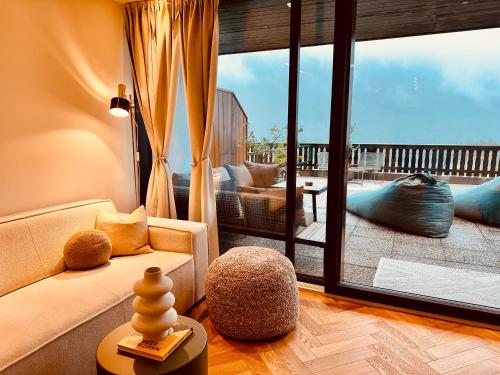 a living room with a couch and a large window at Das Alpenzeit Appartement mit Just Private Terrasse in Bad Aussee