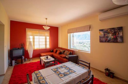 a living room with a couch and a table at Cozy Hilltop Home with Breathtaking Views in Magoúla