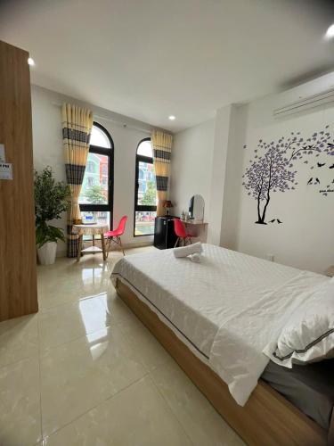 a bedroom with a large bed and a table and chairs at Thiên Ý Homestay in Phu Quoc
