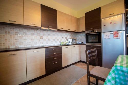 a kitchen with wooden cabinets and a blue refrigerator at Cozy Hilltop Home with Breathtaking Views in Magoúla