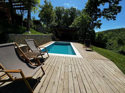 a deck with two chairs and a swimming pool at Šumska Vila Lipovica in Barajevo
