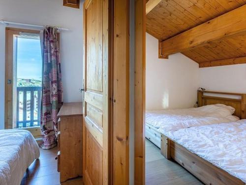 une chambre avec deux lits et une grande fenêtre dans l'établissement Chalet 6 pièces sur les pistes à La Plagne, 10 pers, garage, balcon, ensoleillé, ski-in/ski-out - FR-1-351-85, à Plagne Villages