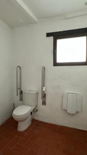 a bathroom with a toilet and a window at Apartamentos Jerez Siglo XIX in Jerez de la Frontera