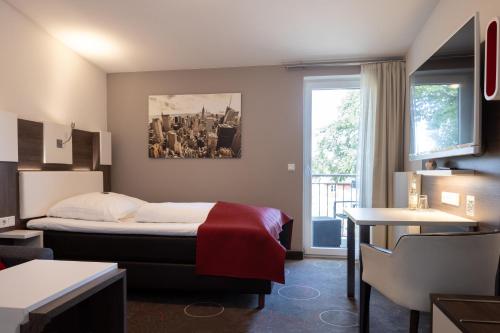 a hotel room with a bed and a window at Hotel Gasthof Handewitt in Handewitt