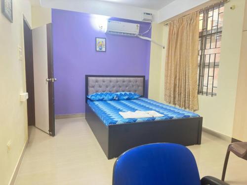a bedroom with a bed with a purple wall at Dreams Abode Homestay in Guwahati