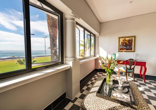 a room with windows and a table with flowers at The Winchester Hotel by NEWMARK in Cape Town