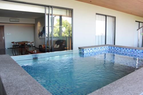 a swimming pool with blue tile on the side of a house at Moscato Hotel in Lembang