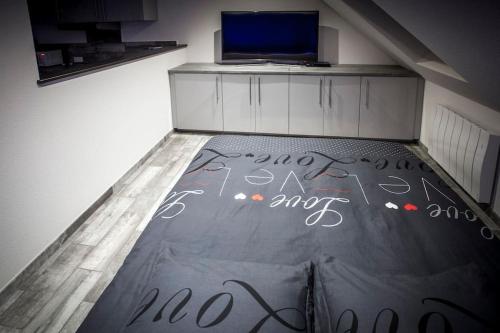 Cette chambre dispose d'un mur avec un bureau au sol. dans l'établissement VIP 2 Loft avec spa privatif à 10 min de Dijon, à Fauverney