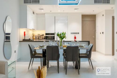 a dining room with a table and chairs at 2 Bed Apt in District One Dubai - Lagoon Views in Dubai