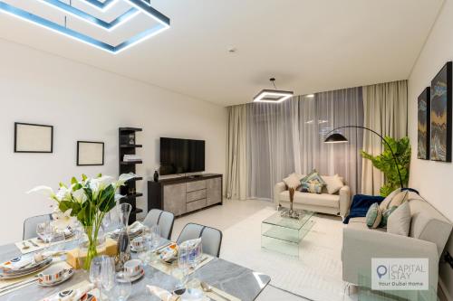 a living room with a dining table and a couch at 2 Bed Apt in District One Dubai - Lagoon Views in Dubai
