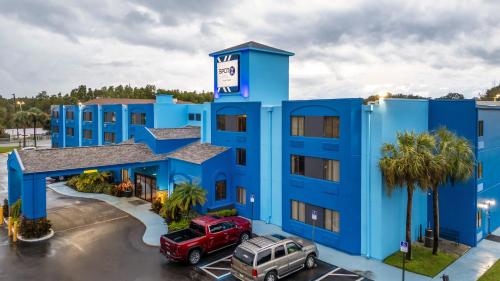 a blue hotel with cars parked in front of it at SPOT X Hotel Tampa - Wesley Chapel by The Red Collection in Wesley Chapel