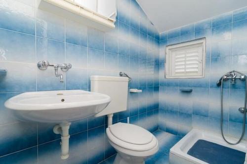 un bagno piastrellato blu con un water e un lavandino di Apartment Sutvid with one bedroom a Drače