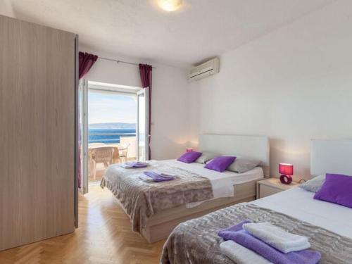 a bedroom with two beds and a view of the ocean at Apartments Nena ST - Standard One Bedroom Apartment with Balcony and Sea View A2 in Pisak