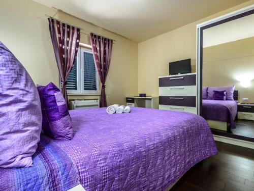 a bedroom with a purple bed and a mirror at Villa Pave - Six-Bedroom Villa with Terrace and Swimming Pool in Dubravka