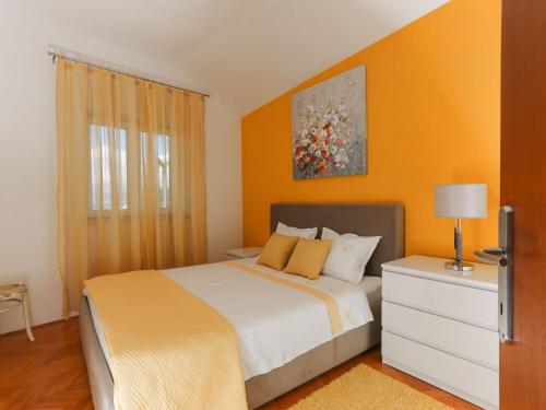 a bedroom with a large bed with orange walls at Apartment Tonka - Two Bedroom Apartment - ST in Supetar